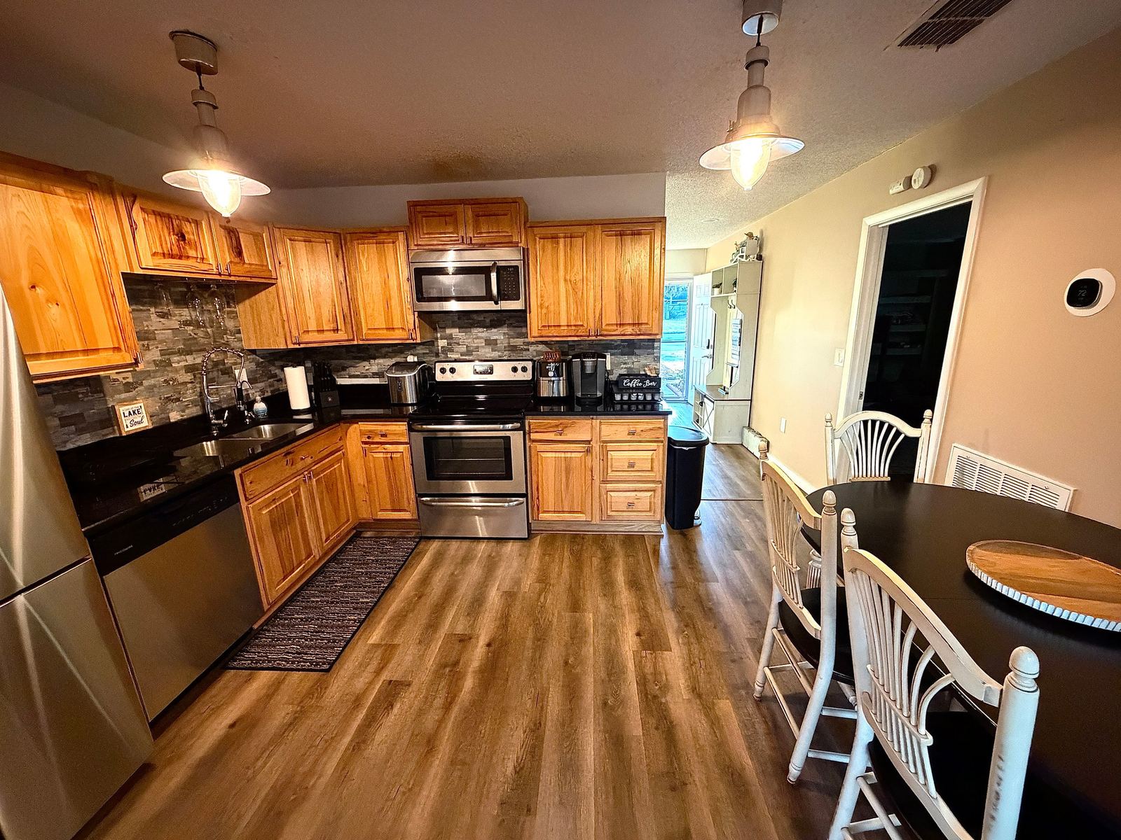 Fully equipped kitchen with stainless appliances, granite counters, and dining table